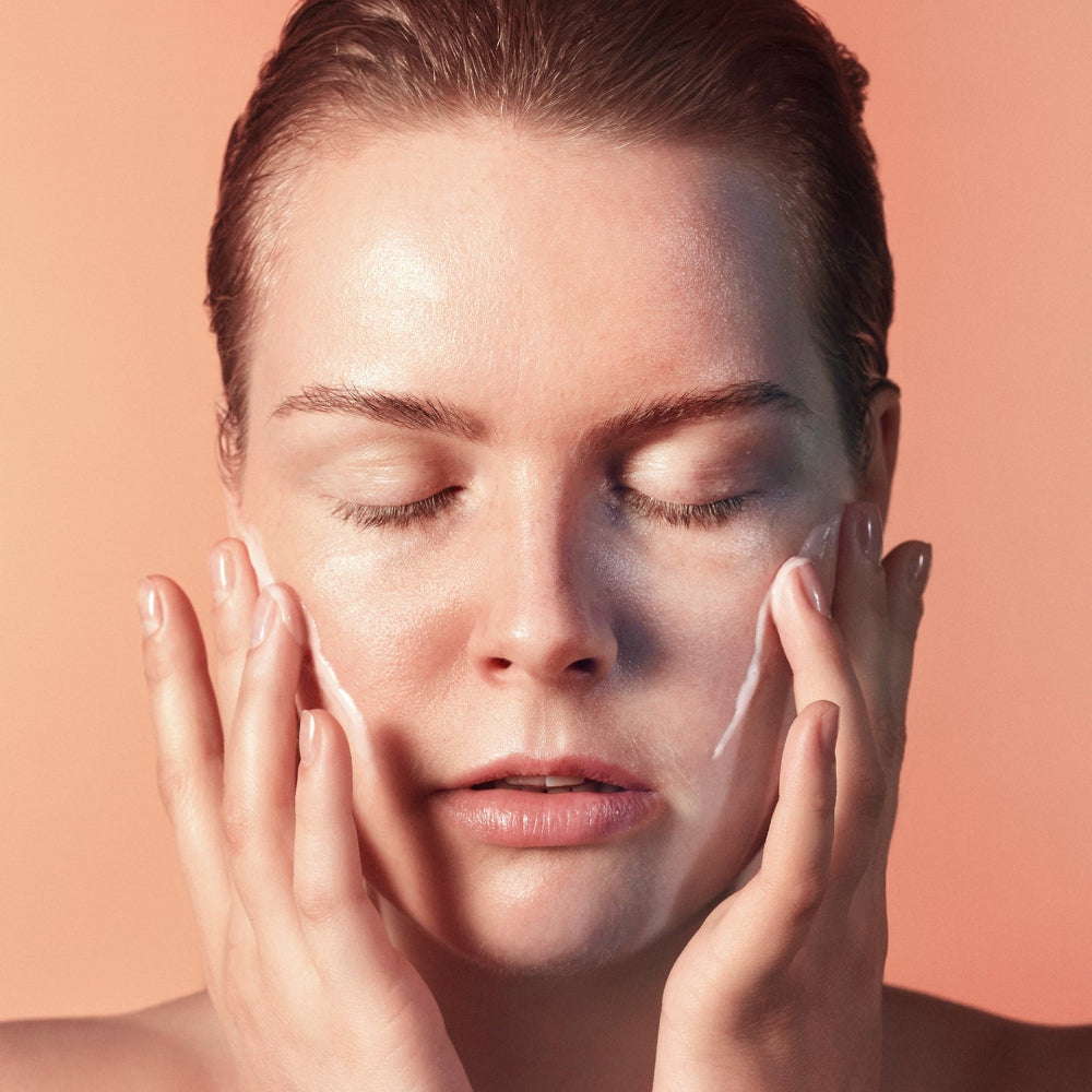 Modelo aplicando la crema facial hidratante Mádara SOS Hydra Recharge sobre el rostro
