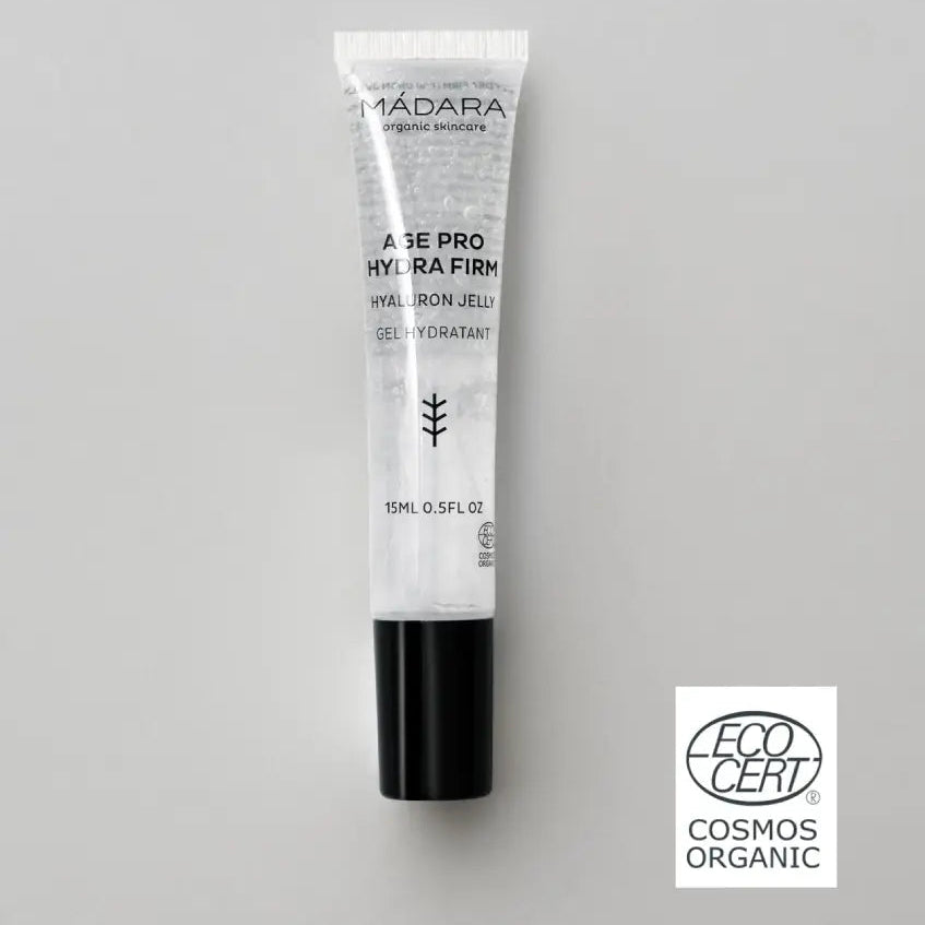 Gel hidratante facial Mádara Age Pro Hydra Firm Hyaluron Jelly Mini de 15 ml con sello de certificación EcoCert Cosmos Organic sobre fondo gris.