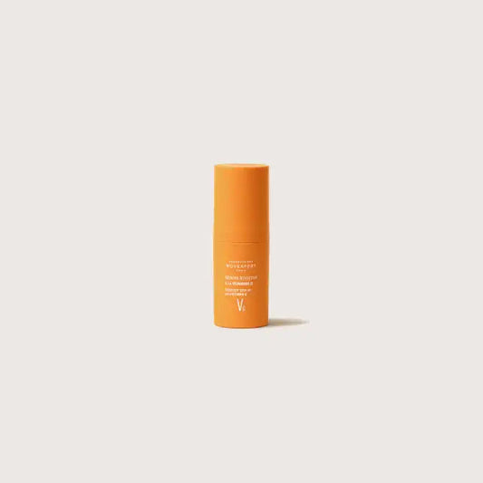 Mini frasco naranja de diez mililitros del Sérum Booster con Vitamina C al 30 por ciento de Novexpert en tamaño de viaje.