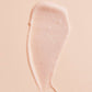 Muestra de la textura ligera y cremosa de color rosa suave de la crema hidratante facial Mádara SOS Hydra Recharge.