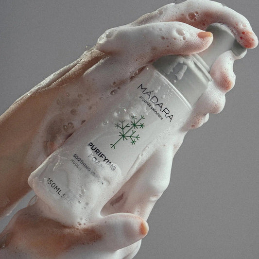 Manos aplicando la textura ligera en espuma de la Limpiadora Purificante de Mádara con abundante espuma blanca